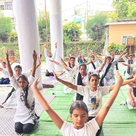 School session: arms raised in a seated pose, June 2025